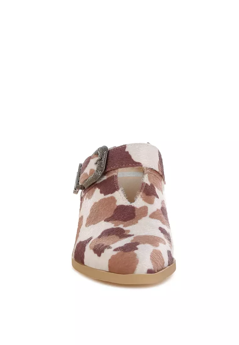 Sandal Mules dengan detail gesper berbahan suede imitasi dengan motif sapi