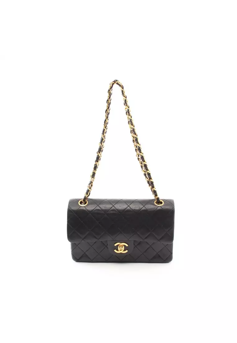 CHANEL Quilted black lambskin bag with rectangular gold…