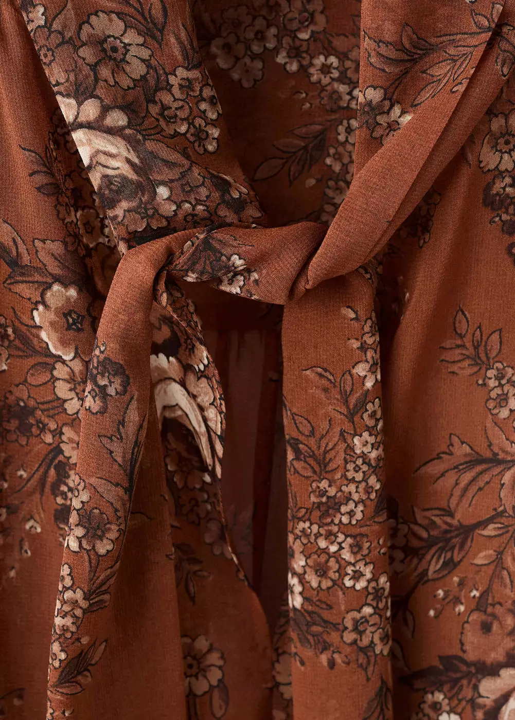 Blus motif floral dengan detail pita