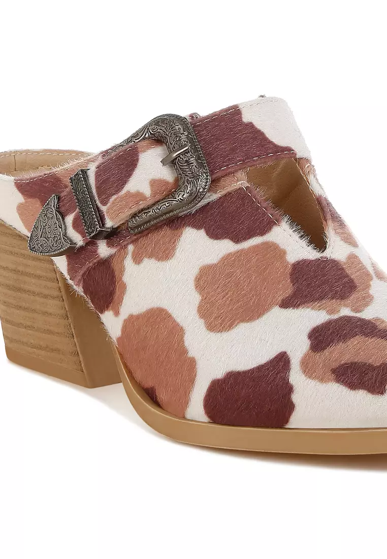 Sandal Mules dengan detail gesper berbahan suede imitasi dengan motif sapi