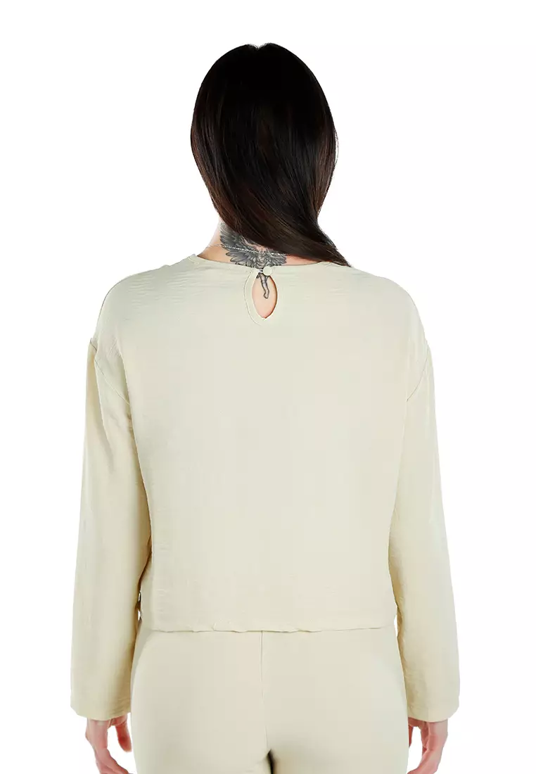 奶油色长袖上衣和合身长裤协调套装